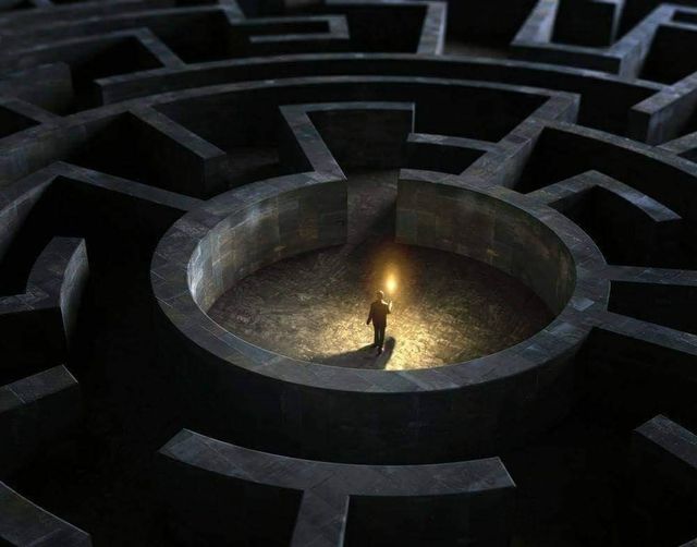 A figure holding a light at the center of a dark circular labyrinth